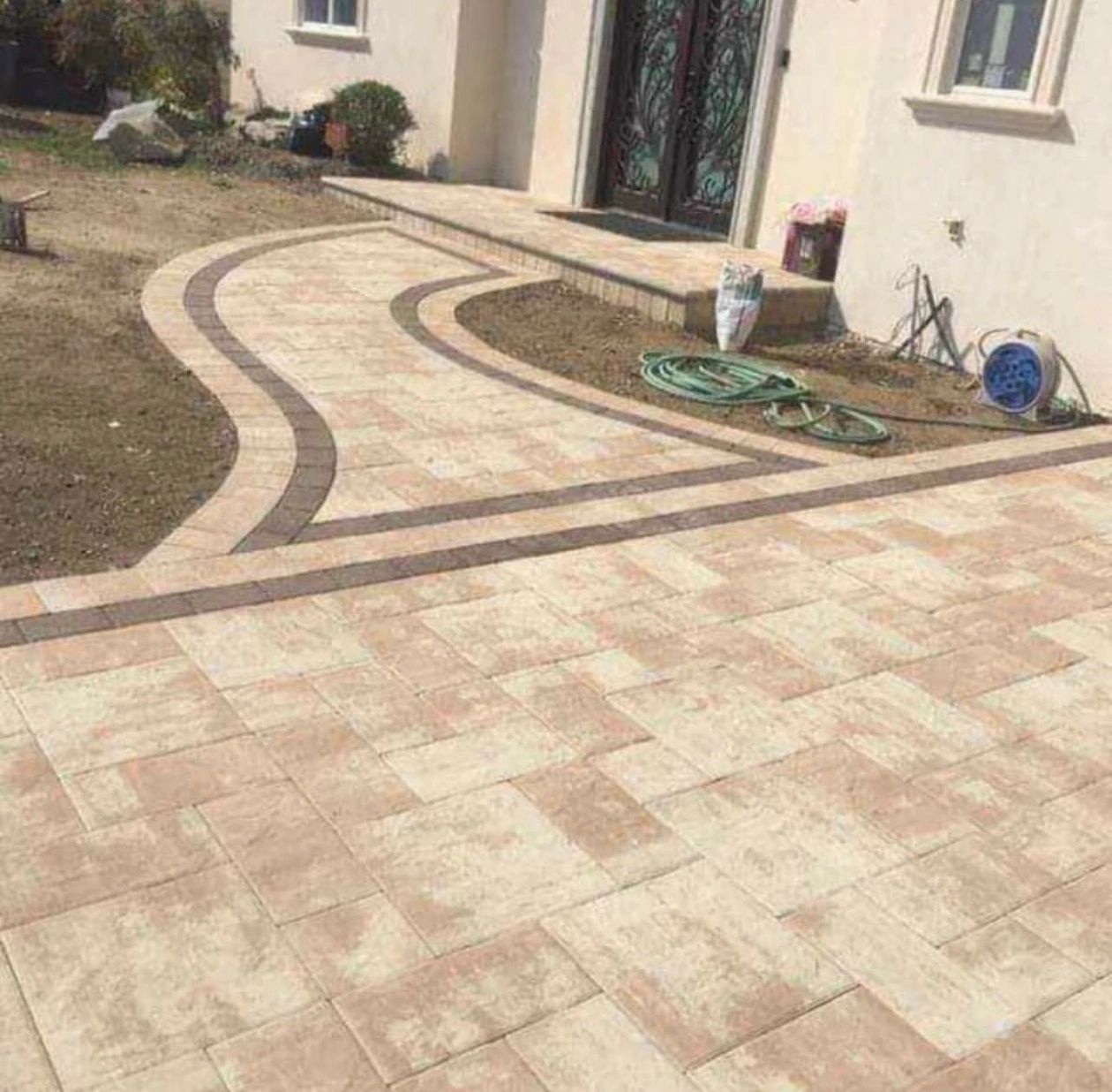 Curved stone paver walkway leading to a home entrance